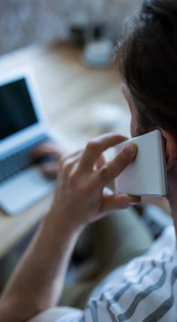 Person calling to book a house cleaning while working on a laptop
